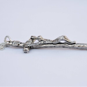 May include: A silver chain necklace with a silver crucifix pendant. The crucifix features a figure of Jesus Christ on a wooden cross.