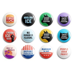 May include: A collection of twelve round buttons with various slogans and graphics. The buttons feature phrases like "Eat the Rich," "Abolish ICE," and "People Over Profit." Colors include black, white, red, green, and purple.