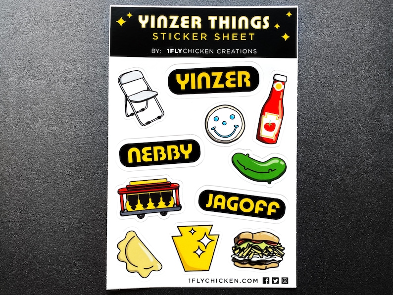 K&ouml;nnte beinhalten: Ein Aufkleberbogen mit verschiedenen Designs zum Thema Pittsburgh, darunter ein Klappstuhl, eine Gurke, ein Smiley, eine Ketchupflasche, ein Pierogi, eine Stra&szlig;enbahn und ein Sandwich. Der Bogen enth&auml;lt auch die W&ouml;rter "Yinzer Things", "Yinzer", "Nebby", "Jagoff" und "1flychicken.com".