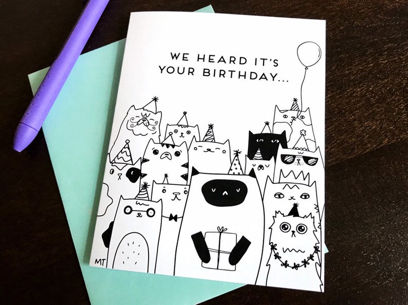 May include: A black and white greeting card with a group of cats wearing party hats and holding a gift. The card reads "We heard it's your birthday..."