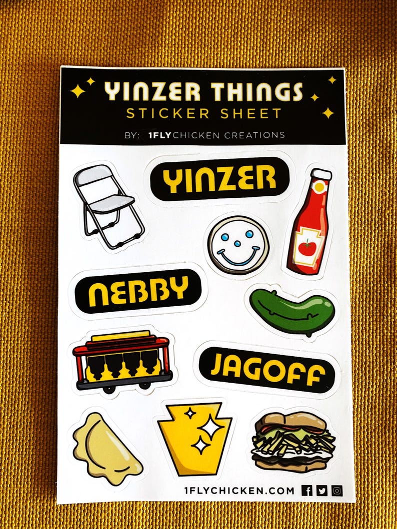 K&ouml;nnte beinhalten: Eine Sticker-Tafel mit verschiedenen Designs zum Thema Pittsburgh, darunter ein Klappstuhl, ein Smiley, eine Ketchupflasche, eine Gurke, eine Stra&szlig;enbahn, ein Pierogi, der Bundesstaat Pennsylvania und ein Sandwich. Die Tafel enth&auml;lt auch den Text "Yinzer Things" und "1flychicken.com".