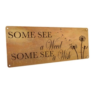 May include: A rustic brown metal sign with the text "Some see a weed, some see a wish" and a silhouette of dandelions with seeds blowing in the wind.