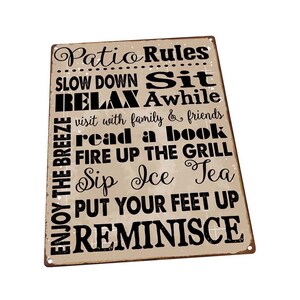 May include: A tan metal sign with black text that reads "Patio Rules" and lists a series of rules for enjoying a patio, such as "Slow Down Sit Relax Awhile", "Visit with family & friends", "Read a book", "Fire up the grill", "Sip Ice Tea", "Put your feet up", and "Reminisce".