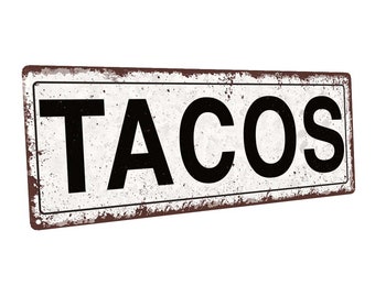 May include: A white metal sign with a rusty brown border. The sign has black text that reads "TACOS".