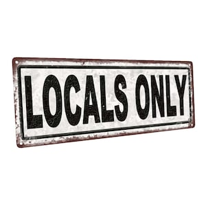May include: A white metal sign with a rusty brown border. The sign reads "LOCALS ONLY" in black letters.