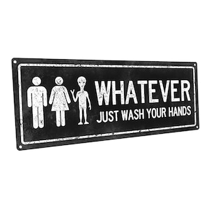 May include: Black and white metal sign with a distressed look. The sign features a male, female, and alien restroom symbol with the text "WHATEVER JUST WASH YOUR HANDS".