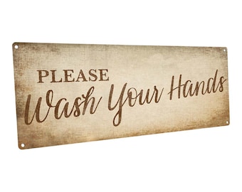 May include: A rustic brown metal sign with the text "PLEASE Wash Your Hands" in a brown cursive font on a beige background.