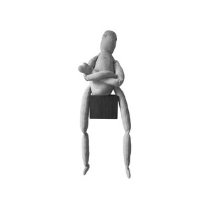 May include: A gray fabric doll with a minimalist design. The doll is seated on a dark wooden block, with its arms crossed and legs dangling. The doll's head is oval-shaped, and the body is made of soft fabric.