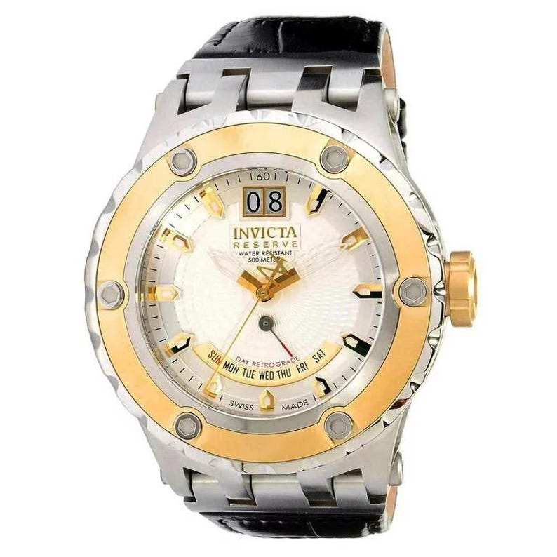 May include: A gold and silver Invicta Reserve watch with a white face, black leather band, and a date window displaying "08". The watch is water resistant to 500 meters.