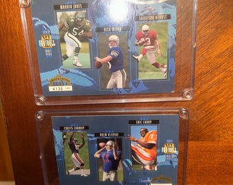 Könnte beinhalten: Zwei transparente Kunststoffhüllen mit NFL-Football-Sammelkarten von 1993. Die Karten zeigen Actionaufnahmen von Spielern wie Maruta Jones, Rich Mider und Garrison Hearst. Jede Karte hat einen blauen Hintergrund.