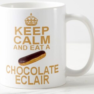 May include: White ceramic mug with a gold design that says "Keep Calm and Eat a Chocolate Eclair".