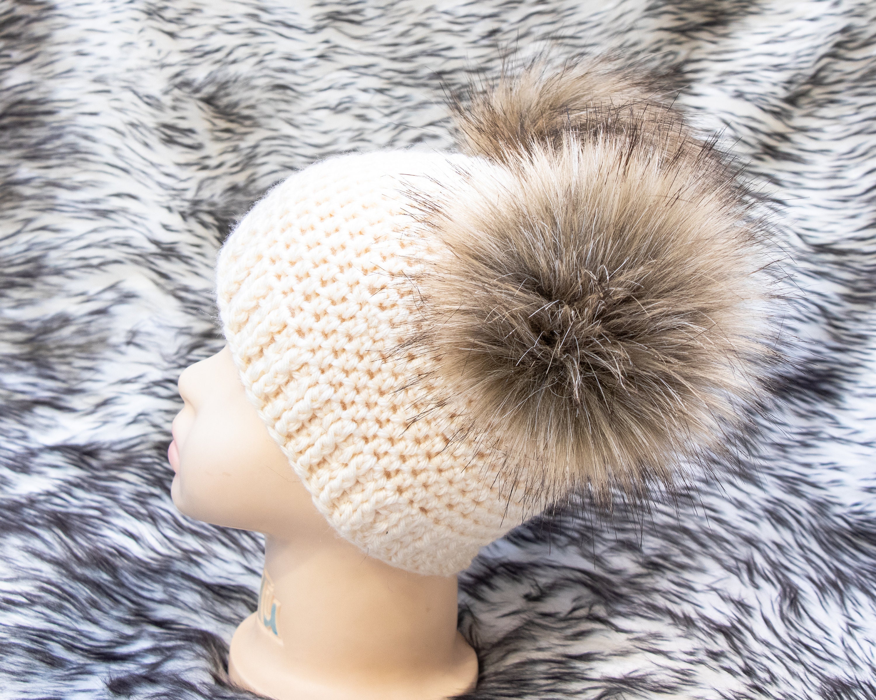 cream hat with fur pom pom