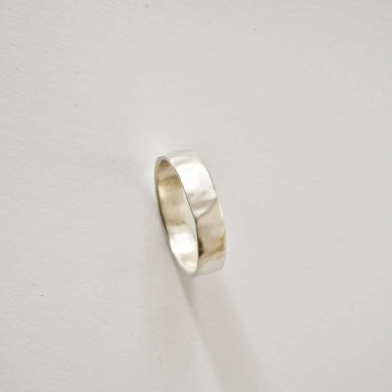May include: A silver hammered band ring.