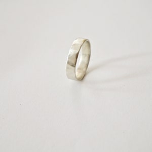 May include: A silver hammered band ring.