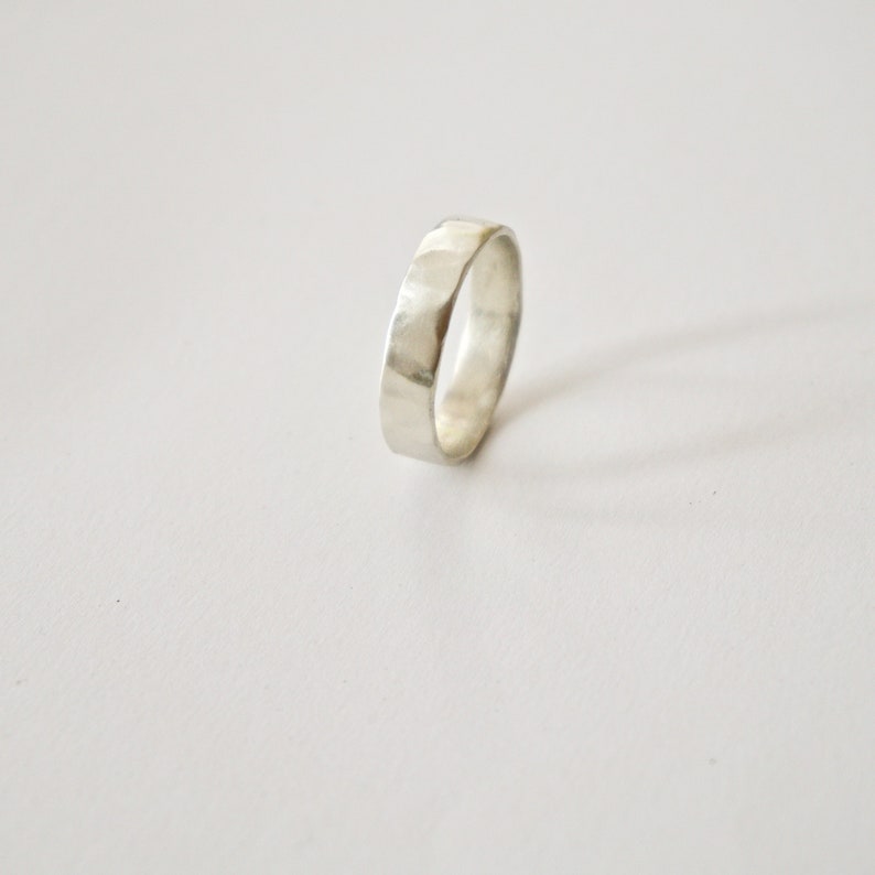 May include: A silver hammered band ring.
