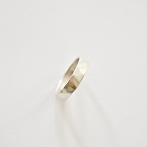 May include: A silver hammered band ring.