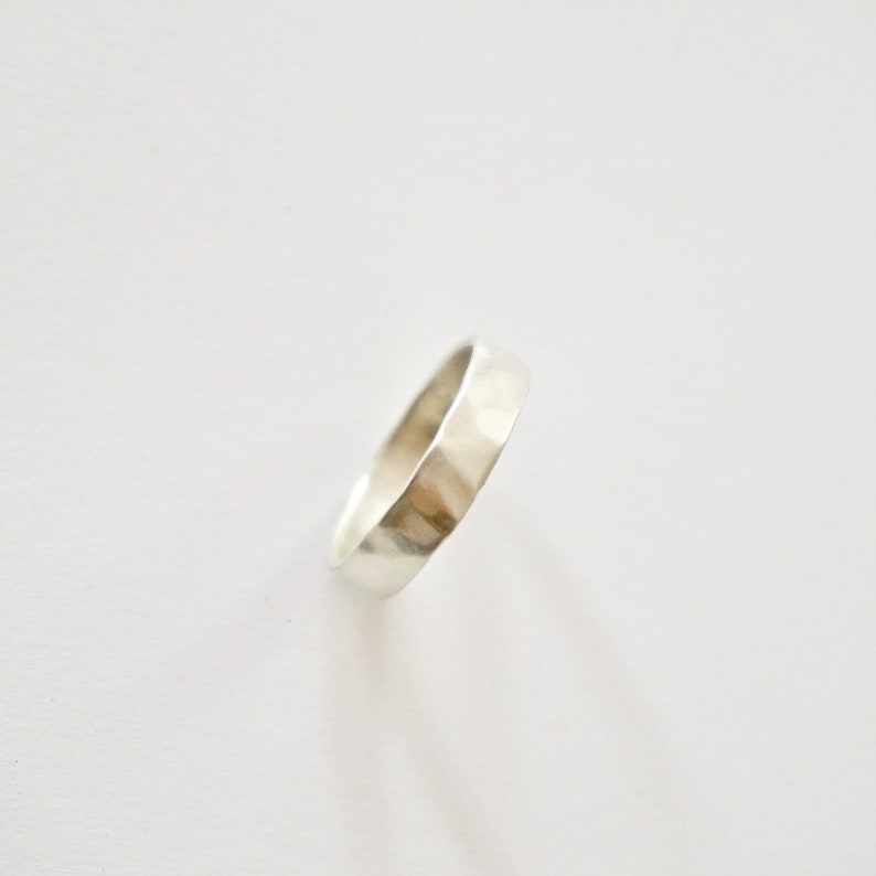 May include: A silver hammered band ring.