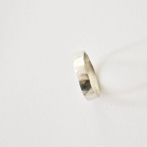 May include: A silver hammered band ring.