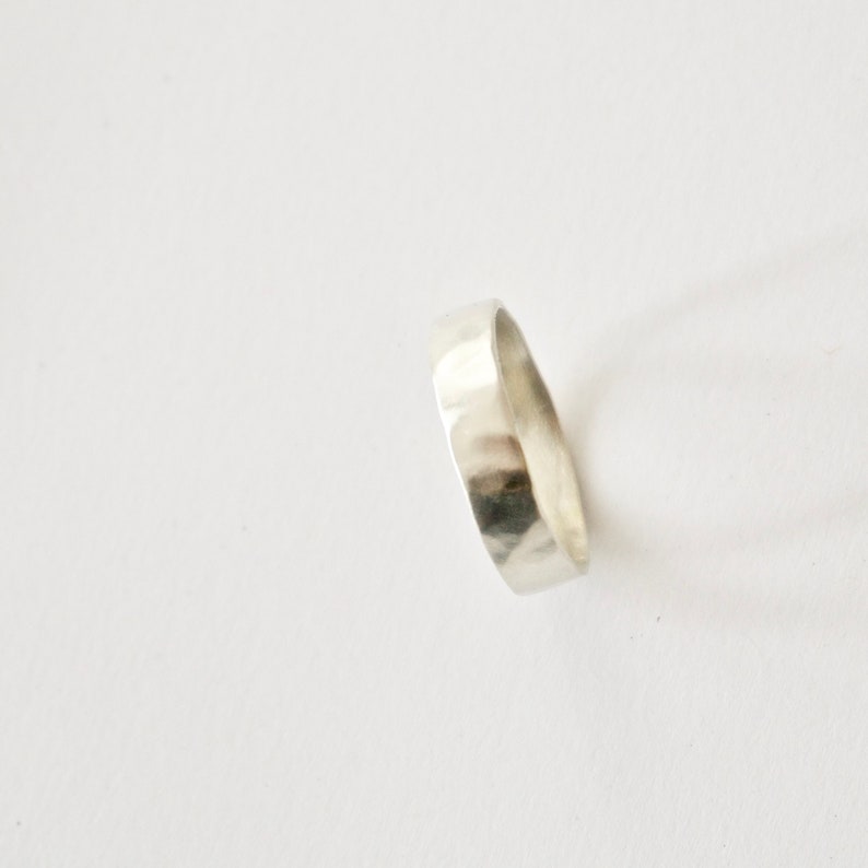 May include: A silver hammered band ring.