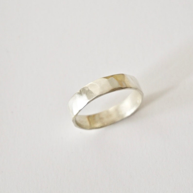 May include: A silver hammered band ring.