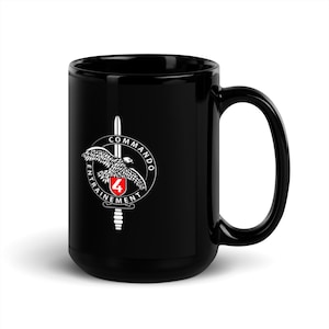 May include: Black ceramic mug with a white graphic of a sword and a bird with the text "Commando Entrainement 4".
