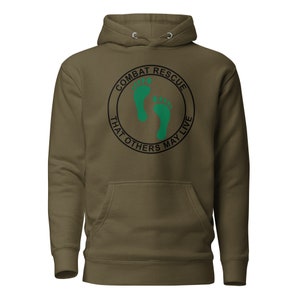 May include: A green and black hooded sweatshirt with the text "Combat Rescue That Others May Live" in a circle with two green footprints inside.
