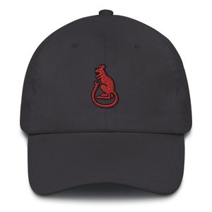 Könnte beinhalten: Eine dunkelgraue Baseballkappe mit einem roten gestickten Rattenmotiv.