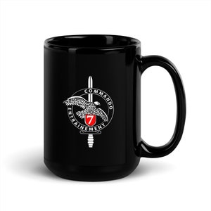 May include: Black ceramic mug with a white graphic of a falcon with a sword and the text "Commando Entrainement 7".