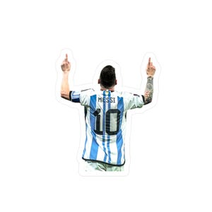Puede incluir: Una pegatina con un jugador de fútbol con una camiseta a rayas blancas y azul claro con el nombre "MESSI" y el número "10" en la espalda. El jugador levanta ambas manos con los dedos medios extendidos.