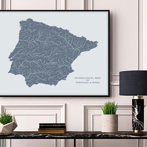 May include: A framed map of Portugal and Spain showing the hydrological network of rivers and streams. The map is printed in blue on a light blue background. The text "HYDROLOGICAL MAP OF PORTUGAL & SPAIN" is printed at the bottom of the map.