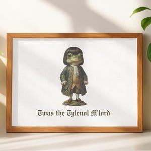 Puede incluir: Una impresión enmarcada que presenta una rana vestida con ropa del siglo XVIII. La rana lleva un abrigo verde, una corbata blanca y una peluca marrón. El texto "Twas the Tylenol M'lord" está impreso debajo. El marco es de madera.