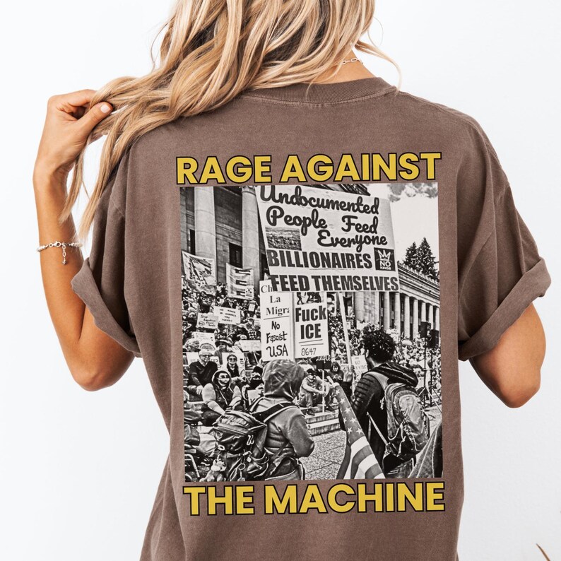 Puede incluir: Camiseta marr&oacute;n con un gr&aacute;fico en la espalda que dice "RAGE AGAINST THE MACHINE". El gr&aacute;fico incluye texto sobre personas indocumentadas, multimillonarios e ICE, junto con una imagen en blanco y negro de una protesta.