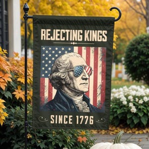 Könnte beinhalten: Eine schwarze Gartenflagge mit einer Illustration von George Washington, der eine Sonnenbrille mit dem Design der amerikanischen Flagge trägt. Die Flagge trägt in weißer Schrift den Text "Rejecting Kings Since 1776" mit einem dekorativen Schriftrollenmuster.