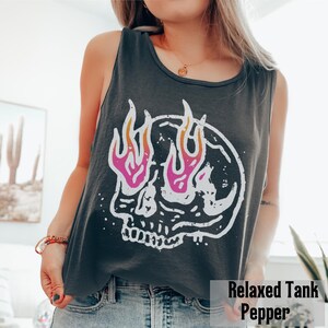 May include: Dark gray tank top with a white skull graphic featuring pink and orange flames. The text "Relaxed Tank Pepper" is at the bottom of the image. The tank top is sleeveless.