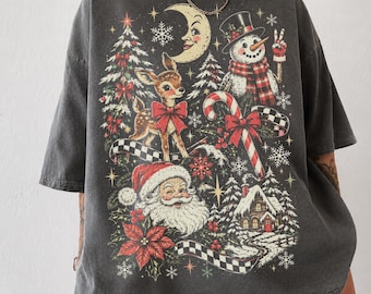 May include: A charcoal grey oversized t-shirt featuring a vintage-style Christmas graphic. The print includes a smiling crescent moon, a fawn with a red bow, a snowman, a candy cane, Santa Claus, a snowy cabin, and poinsettia flowers.