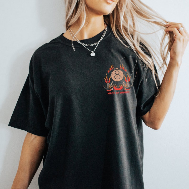 May include: Black t-shirt with a graphic of a red eight ball with flames and the text "Made to Endure".