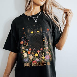 May include: Black t-shirt with a black cat surrounded by colorful flowers and the text "Rage Consumes Me".