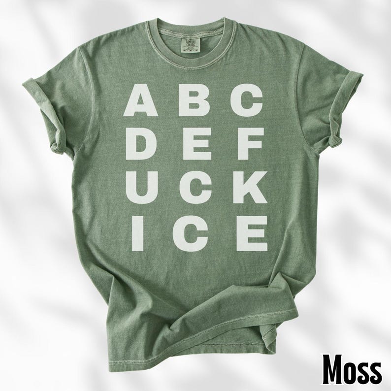 May include: A moss green t-shirt with the word "ABC DEF UCK ICE" printed in white block letters. The shirt has a crew neck and short sleeves. The word "Moss" is printed in the bottom right corner.