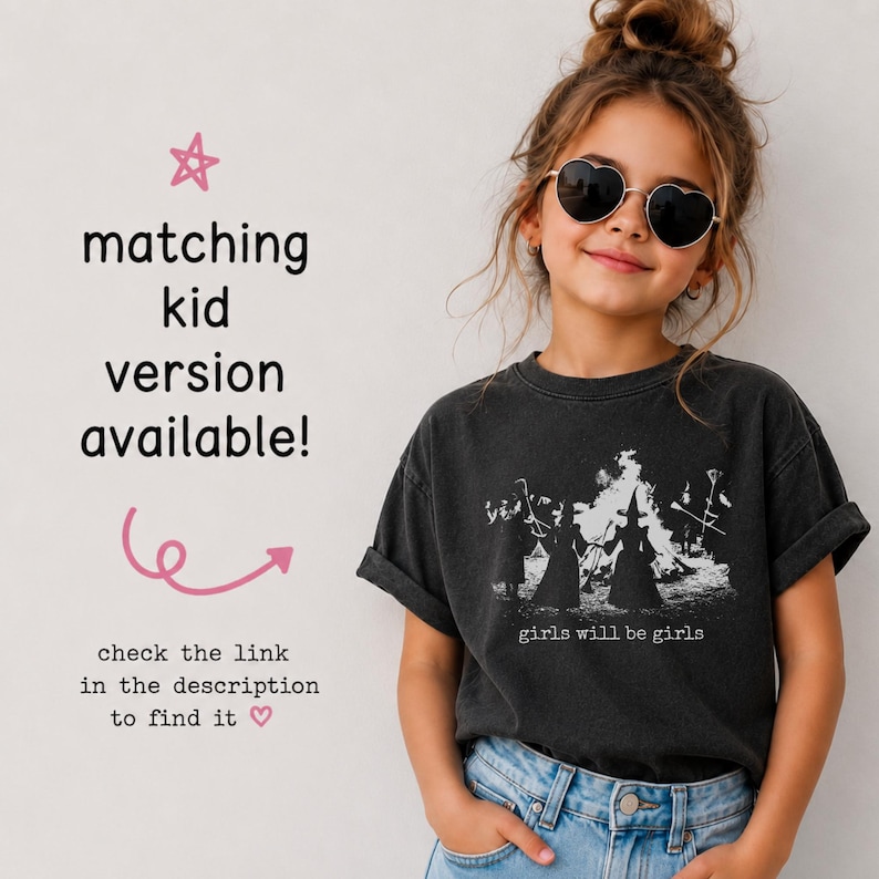 Pu&ograve; includere: Una t-shirt a maniche corte grigio antracite con una stampa grafica bianca di tre figure davanti a un fal&ograve; con il testo "girls will be girls". L'immagine include il testo "matching kid version available!" e "check the link in the description to find it".
