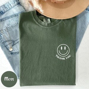 May include: A green t-shirt with a white smiley face and the text "Thank You" on the front.