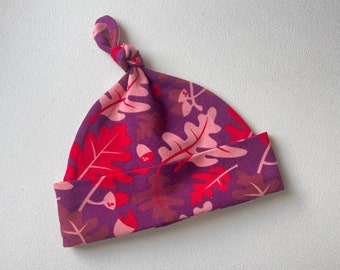 Bonnet avec noeud pour bébé. Bonnet noué. Bonnet noué pour bébé. Taille 3 - 6 mois. Tricot en jersey violet avec des glands et des feuilles. Lillestoff Oakley.