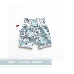 Letzter: Mintfarbene schmal geschnittene Shorts mit weißen tropischen Blättern. Größe 3 Monate. Kleinkind oder Baby Shorts. Bio Baumwollstoff Elvelyckan Monstera Bild 1