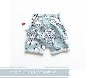 Letzter: Mintfarbene schmal geschnittene Shorts mit weißen tropischen Blättern. Größe 3 Monate. Kleinkind oder Baby Shorts. Bio Baumwollstoff Elvelyckan Monstera