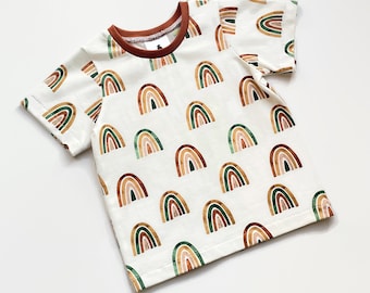 White shirt with watercolour rainbows. Off white top with short sleeves. Kid's shirt with rainbows.