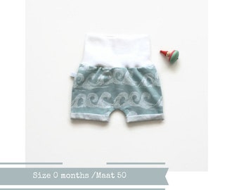 Letzter: Mintfarbene Baby- oder Kleinkindershorts mit weißen Wellen. Bequeme schmal geschnittene Shorts. Strickstoff aus Bio-Baumwolle.