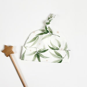 White hat with watercolour leaves and stars. Baby newborn knotted hat image 2