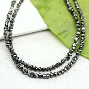 May include: A set of three ceramic mugs with a speckled, matte finish. The mugs are in shades of cream, light grey, and dark grey. Each mug has a simple, minimalist design, ideal for coffee or tea.