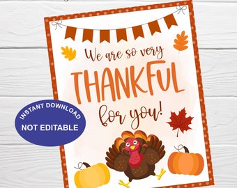 May include: Thanksgiving-themed printable sign with the text "We are so very THANKFUL for you!" in orange. The design includes a cartoon turkey, pumpkins, and fall leaves. A blue circle reads "INSTANT DOWNLOAD NOT EDITABLE".