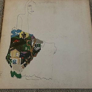 May include: Album cover art featuring a minimalist line drawing of a woman's face and upper body. The lower portion of the figure is filled with a colorful illustration of houses, trees, and a car. The background is off-white.