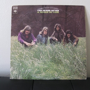 May include: Album cover for "Ten Years After - A Space in Time." The album art features four men in long hair, seated in tall grass. The background shows a dark forest. The Columbia Records logo is visible.